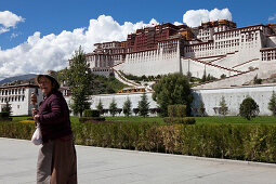 Pilger mit Gebetsmühle vor dem Potala-Palast, Residenz und Regierungssitz der Dalai Lamas in Lhasa, autonomes Gebiet Tibet, Volksrepublik China