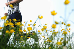 Frau läuft durch eine Blumenwiese, Oberbayern, Bayern, Deutschland