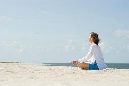Frau macht Yoga am Strand, List, Sylt, Schleswig-Holstein, Deutschland