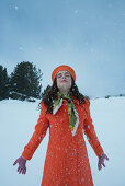 Teenage girl standing in snow with head back, eyes closed