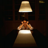 Woman at end of table leaning on elbows