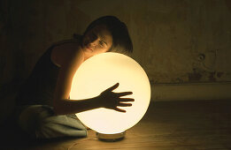 Woman holding glowing orb lamp