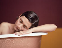 Woman in bathtub, head on edge of tub