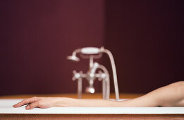 Woman's arm on edge of bathtub