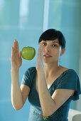 Apple floating in air between woman's hands