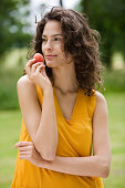 Young woman holding an apricot