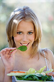Portrait of a young woman eating salad