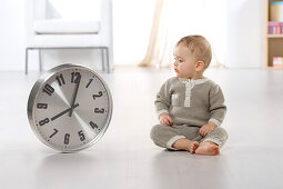 Baby looking at clock on floor