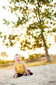 Smiling Child Sitting on Beach, Stratford, Connecticut, USA