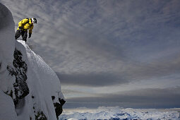 Snowboarder steht auf einem Berggipfel, Chandolin, Anniviers, Wallis, Schweiz