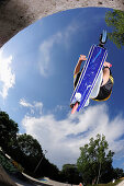 Junger Mann im Sprung mit einem Tretroller, Skatepark, München, Oberbayern, Bayern, Deutschland