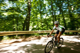 Man road cycling in forest, Bergisches Land, North Rhine-Westphalia, Germany