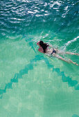 Frau schwimmt im Pool von Kreuzfahrtschiff MS Astor (Transocean Kreuzfahrten) während einer Kreuzfahrt durch die Ostsee, nahe Dänemark, Europa MR
