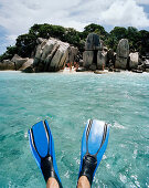 Snorkelling in shallow water over coral reef near tiny Coco Island, La Digue and Inner Islands, Republic of Seychelles, Indian Ocean