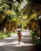 Frau in Kokospalmenplantage L'Union Estate, La Digue, La Digue and Inner Islands, Republik Seychellen, Indischer Ozean