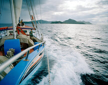 Transport sailer La Belle Praslinoise on its way to La Digue, dark rain clouds over La Digue, La Digue, La Digue and Inner Islands, Republic of Seychelles, Indian Ocean