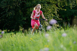 Frau fährt E-Bike, Radtour, Rosensteinpark, Stuttgart, Baden-Württemberg, Deutschland