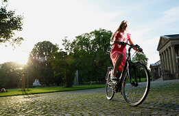 Woman cycling through Rosenstein Park on an E-Bike, bike tour, e-bike, Rosenstein Park, Stuttgart, Baden-Wurttemberg, Germany