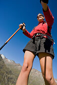 Young woman with hiking poles under a blue sky, Obergurgl, Oetztal Alps, Tyrol, Austria, Europe