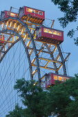View over trees onto illuminated ferris wheel, Prater, 2. Bezirk, Leopoldstadt, Vienna, Austria, Europe