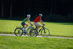 Cyclists riding e-bikes, Lake Starnberg, Bavaria, Germany