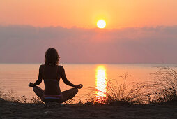Frau macht Yoga bei Sonnenaufgang am Mittelmeer, lykische Küste, Lykien, Türkei, Europa