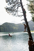 Four boys at lake Alatsee, near Fuessen, Allgaeu, Bavaria, Germany