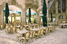 Snow covered chairs and tables outside Orlando, Platzl, Munich, Bavaria, Germany
