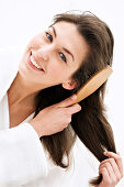 Porträt einer jungen Frau beim Bürsten ihrer Haare