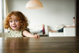 Little girl looking at the camera, coffee table in the foreground