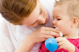 Close-up of a young woman wiping her son's mouth