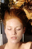 Young woman lying outdoors, sunbathing