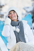 Young woman using mobile phone in snow