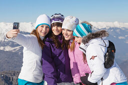 Four teenage girls in ski clothes, taking self portrait