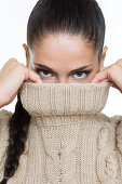 Young woman covering her face with sweater