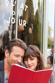 Couple reading menu at a restaurant, Paris, Ile-de-France, France