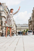 Woman hailing a taxi, Paris, Ile-de-France, France