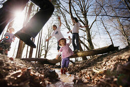 Kinder toben am Seeufer und springen über einen Bach, Schlosspark Leoni, Leoni, Berg, Starnberger See, Bayern Deutschland