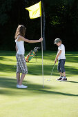 Children playing golf, Bergkramerhof, Bavaria, Germany