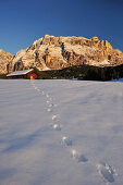 Snow-covered hay shed beneath Heiligkreuzkofel, Footprints in the snow, Val Badia, Dolomites, UNESCO World Heritage Site, South Tyrol, Italy