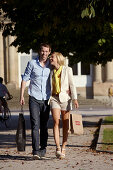 Junges Paar promeniert mit Eikaufstüten, Shopping, Schlossplatz, Neues Schloss, Stuttgart, Baden Württemberg, Deutschland