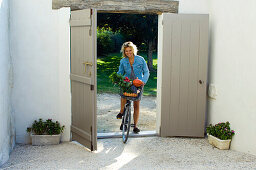 Woman on bicycle with basket of vegetables