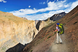 Frau mit Rucksack blickt über eine Schlucht, Snertse, Großer Zanskar Trek, Zanskargebirge, Zanskar, Ladakh, Jammu und Kashmir, Indien