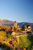 Schloss Tirol mit herbstlich verfärbten Weinbergen und Sarntaler Alpen im Hintergrund, Schloss Tirol, Meran, Südtirol, Italien, Europa