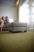 Couple sitting on a couch inside a hotel room, Brussels, Belgium