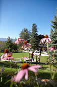 Children balancing over a wooden beam near a nature hotel, Am Hochpillberg, Schwaz, Tyrol, Austria