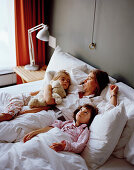 Mother and daughters in a hotel bed, Rotterdam, South Holland, Netherlands