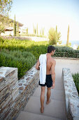 Man with towel on the way to a hotel pool, Ramatuelle, Provence-Alpes-Cate d'Azur, France