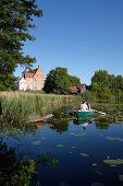 Couple in a rowboat on lake Ulrichshusen, Ulrichshusen castle, Ulrichshusen, Schwinkendorf, Mecklenburg-Western Pomerania, Germany
