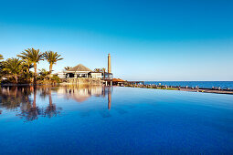Pool des Grand Hotel Costa und Leuchtturm unter blauem Himmel, Meloneras, Maspalomas, Gran Canaria, Kanarische Inseln, Spanien, Europa